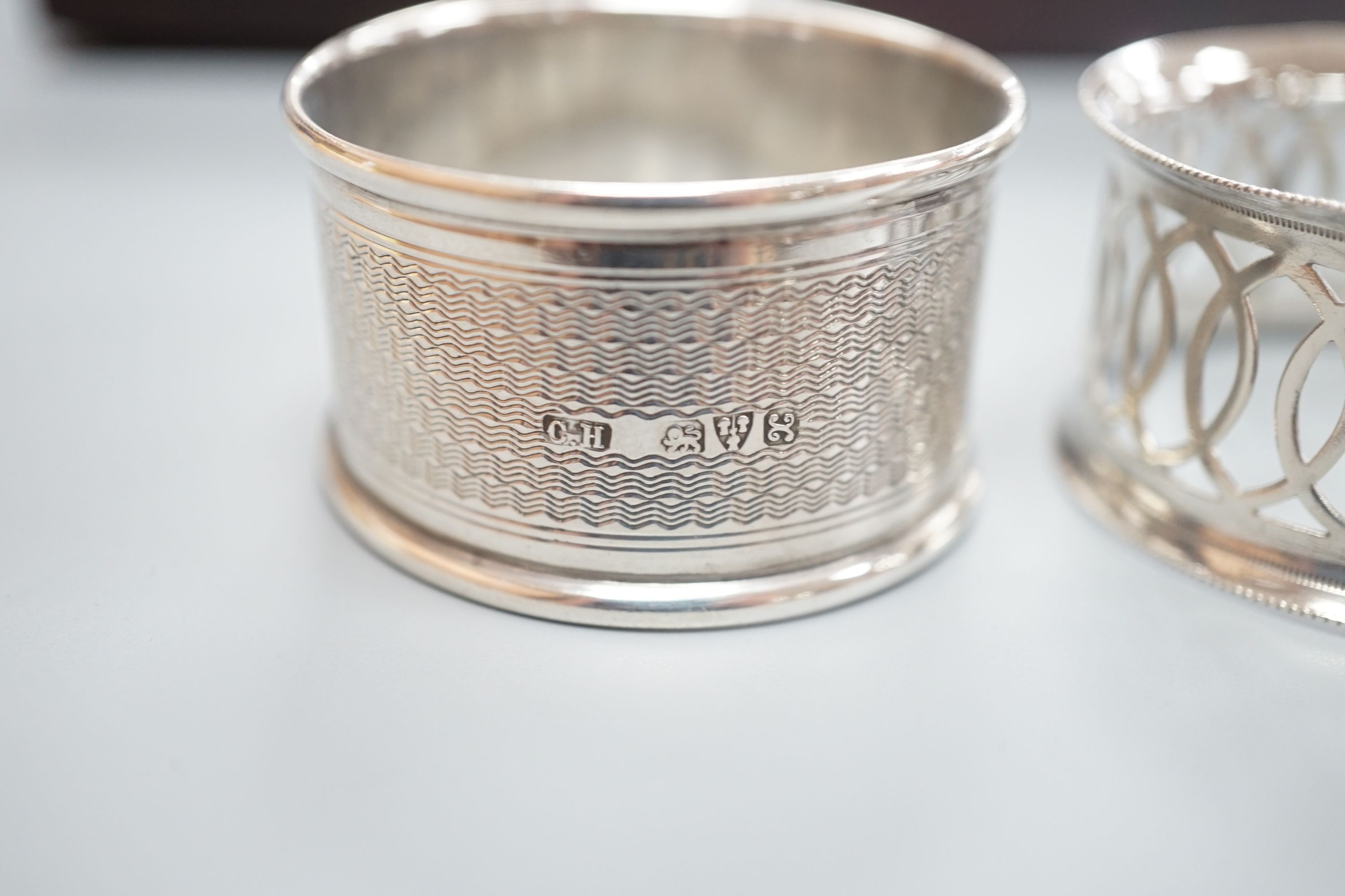 A cased pair of George V engine turned silver napkin rings, by Charles Horner, Chester, 1923 and an Edwardian cased pair of silver napkin rings.